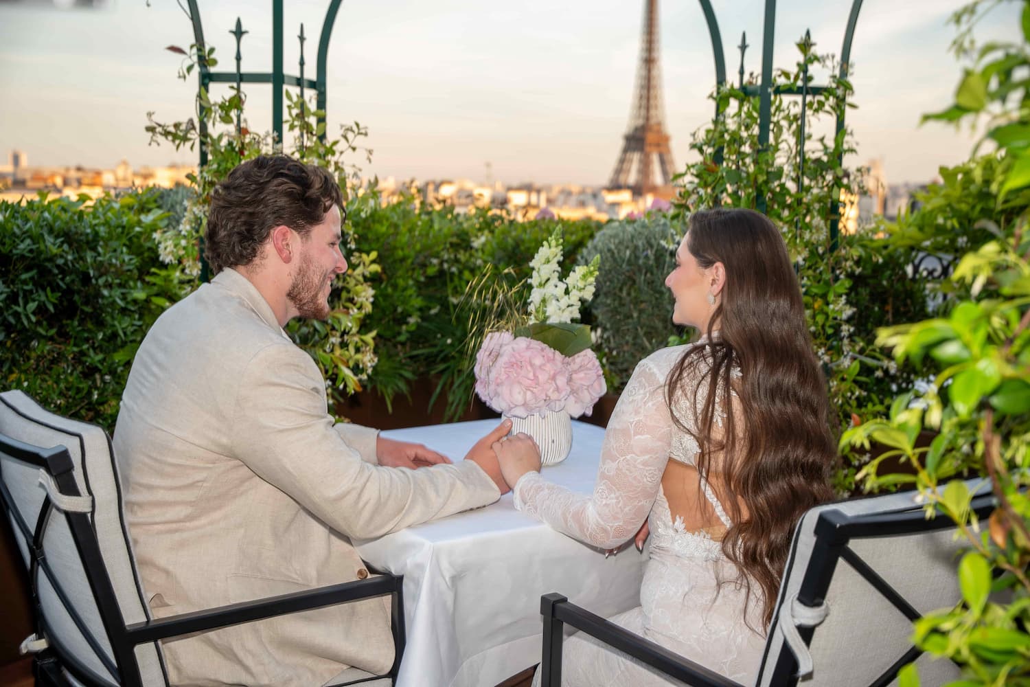 Couple enjoying a private rooftop proposal dinner overlooking the Eiffel Tower in Paris after getting engaged.