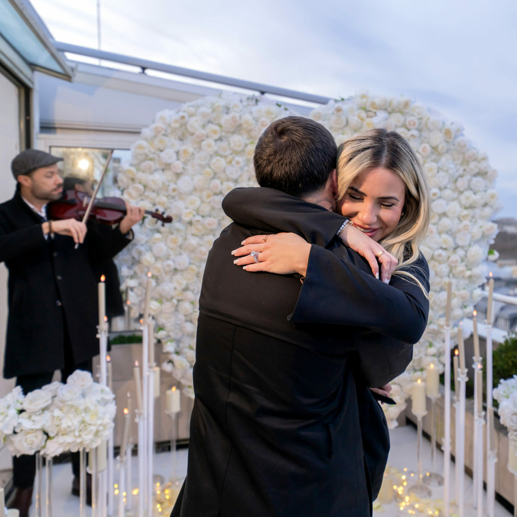 Couple enjoying a beautiful moment for their proposal with a violonist in the background