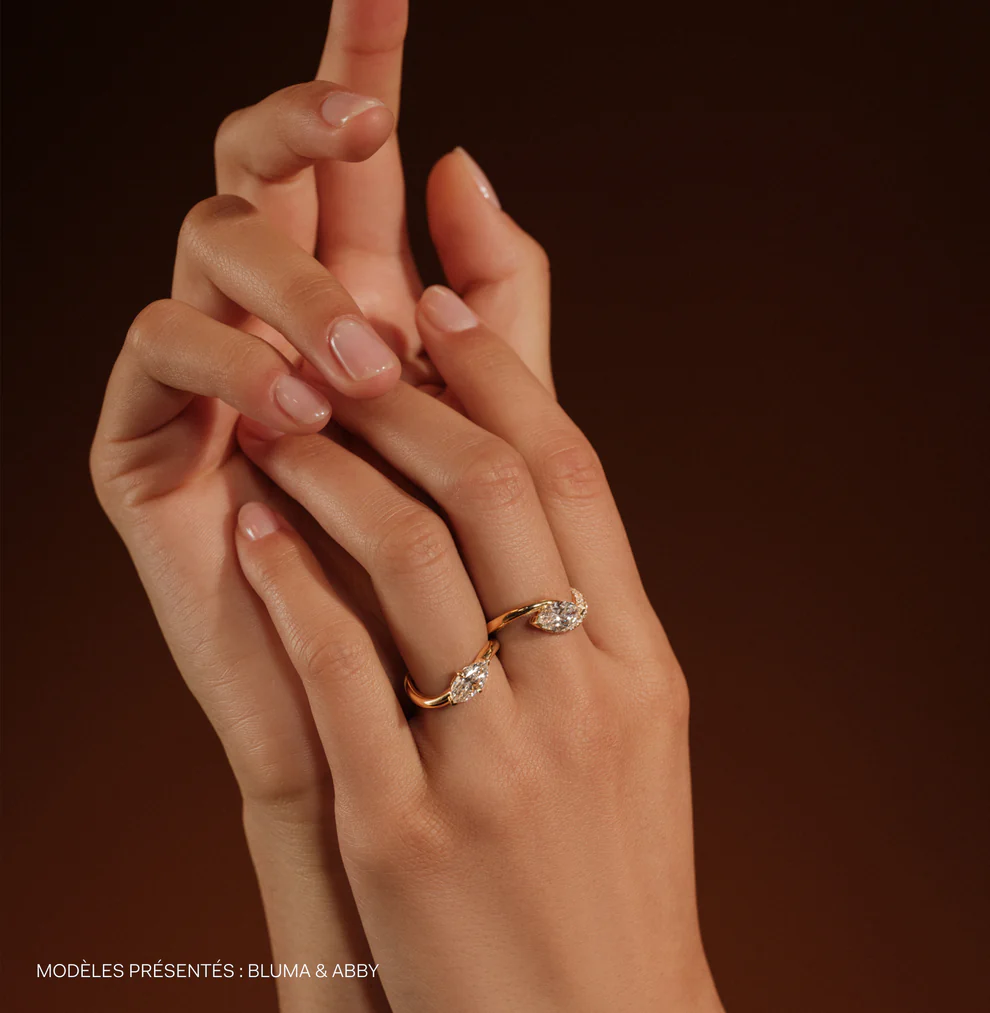 Baunat Bluma and Abby engagement rings on a woman's finger, featuring two marquise-cut diamonds set on a delicate yellow gold twist band, a romantic and unique choice for an engagement ring in Paris