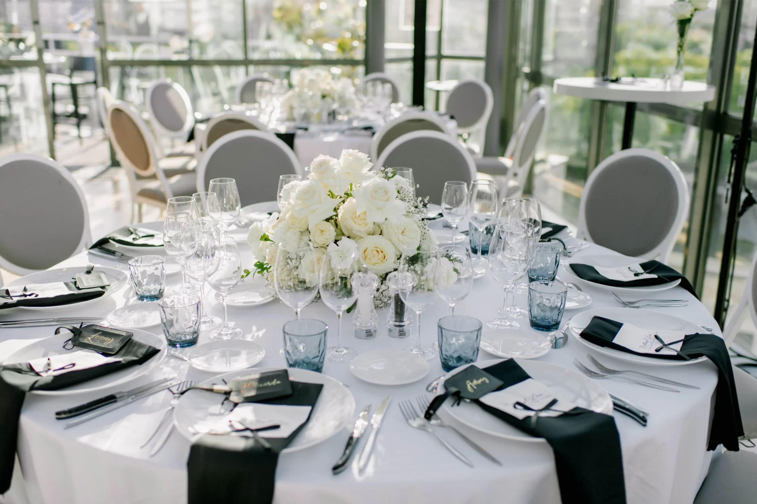 Paris elopement reception table set with a white rose centerpiece and elegant place settings
