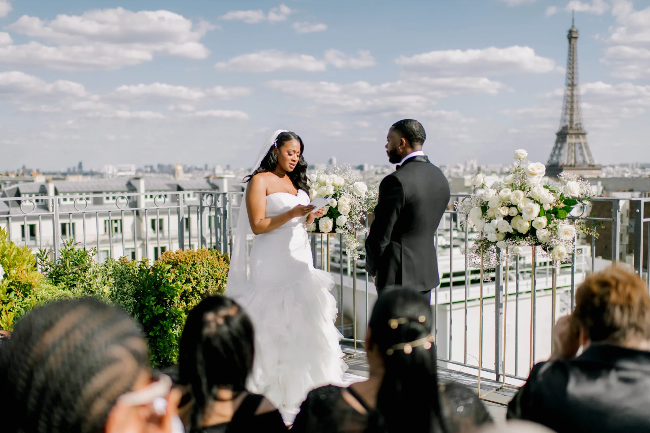 Bride reading her vows to groom during a rooftop elopement ceremony overlooking the Eiffel Tower in Paris