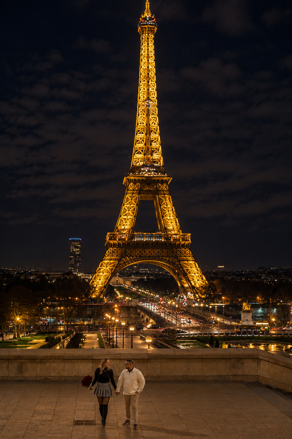 Couple holding hands at night in front of the Eiffel Tower sparkle seen from Trocadéro in Paris