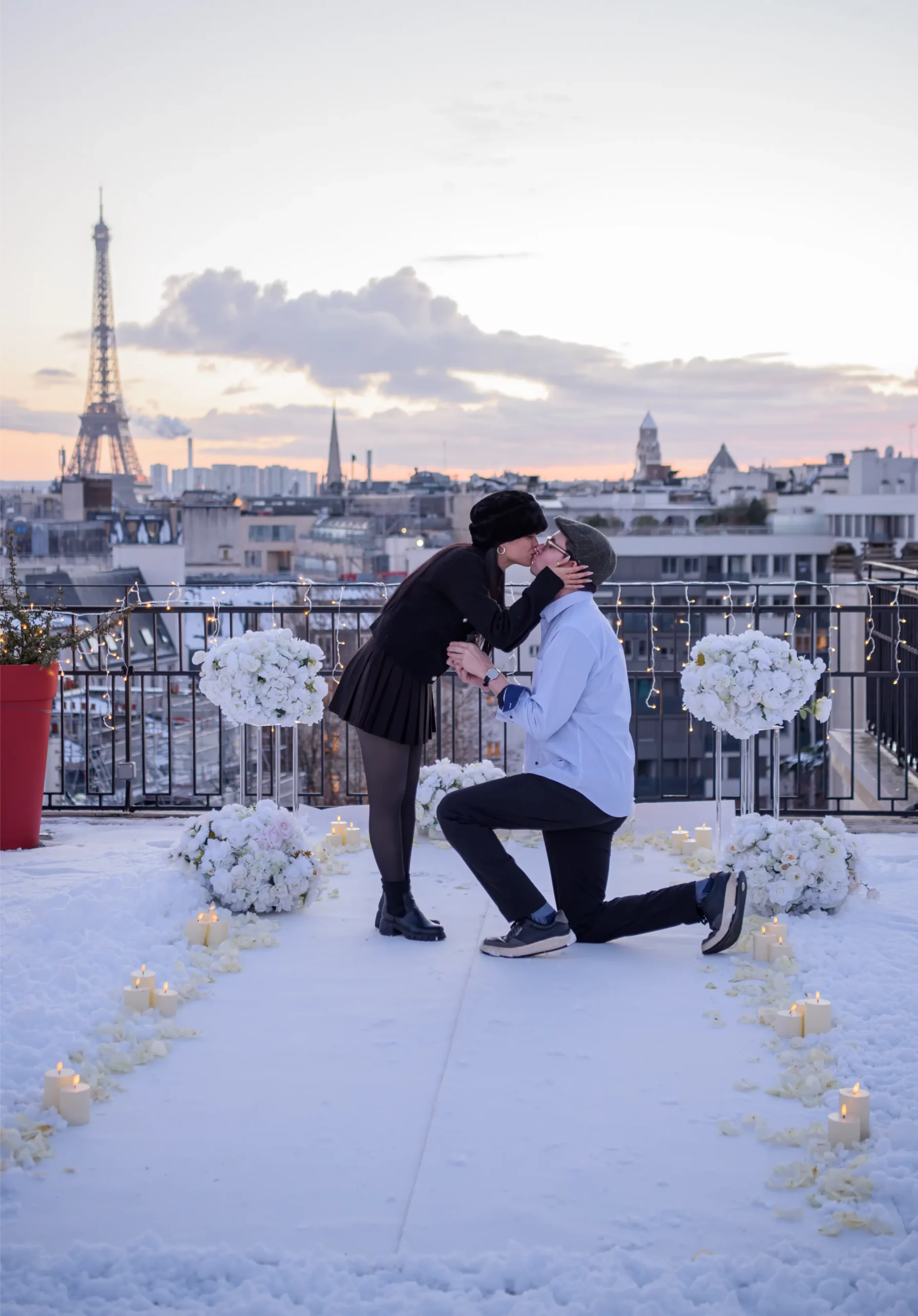 Couple holding hands walking along the Seine in Paris at dusk with the illuminated Eiffel Tower sparkling in the background